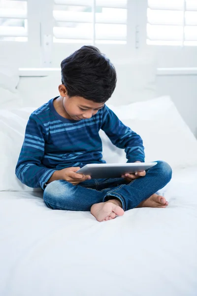 Niño usando la tableta mientras se relaja en la cama —  Fotos de Stock