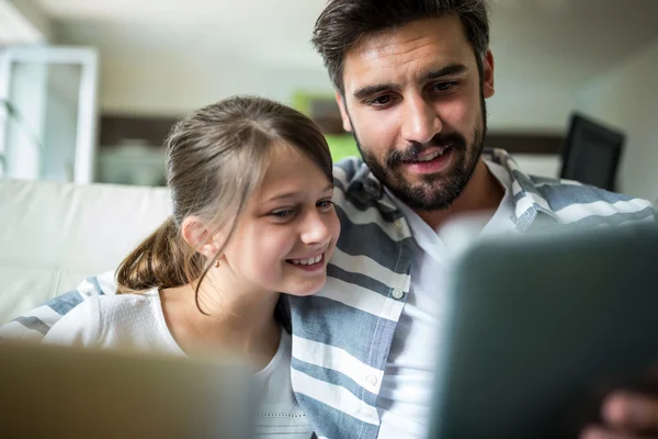 Baba ve kız oturma odasında dizüstü bilgisayar ve dijital tablet kullanarak — Stok fotoğraf