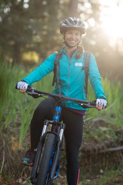 Feminino motociclista com bicicleta de montanha no campo — Fotografia de Stock