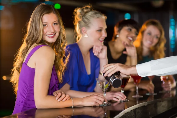 Camarero vertiendo cóctel en copa de mujer Imagen de archivo