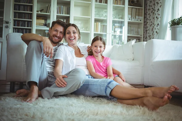 Famiglia seduta sul tappeto in soggiorno — Foto Stock