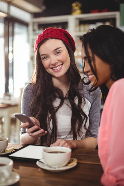 Vrienden met behulp van mobiele telefoon in café — Stockfoto