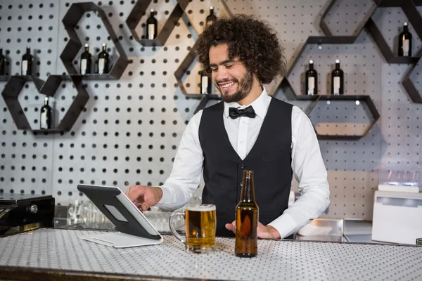 Bartender usando tablet digital no balcão de bar — Fotografia de Stock