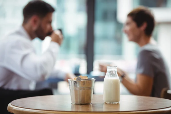 Бутылка молока и ведро на столе — стоковое фото