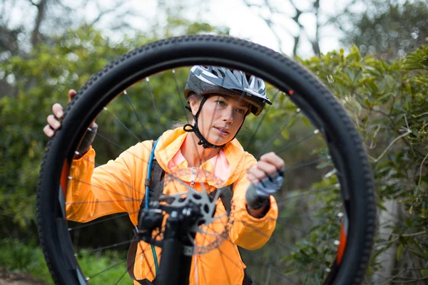 Motociclista feminino reparando bicicleta de montanha — Fotografia de Stock