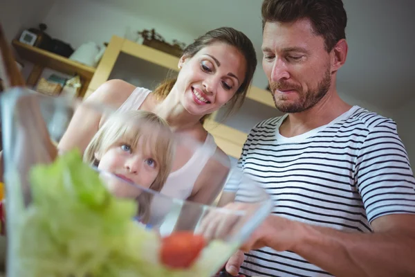 Famille préparant la salade dans la cuisine — Photo