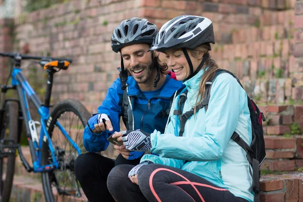 Casal motociclista usando telefone móvel — Fotografia de Stock