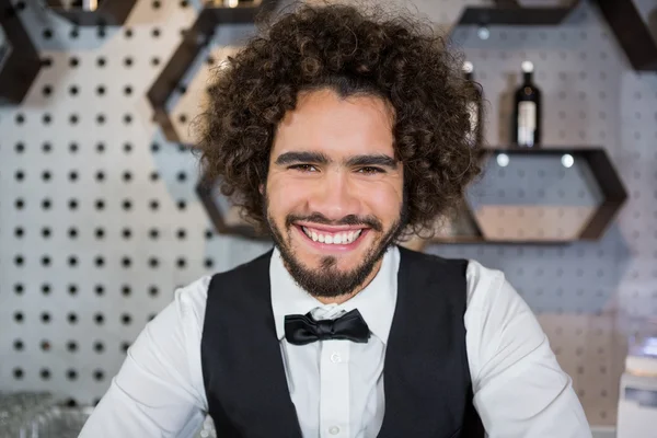 Barman sorridente em pé no balcão do bar — Fotografia de Stock