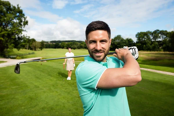 Adam golf club golf sahası ile ayakta — Stok fotoğraf