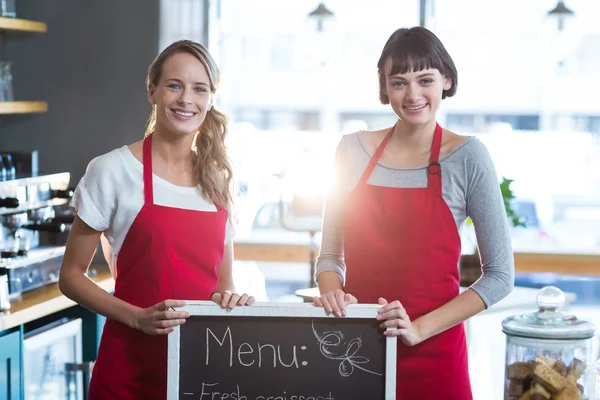 Garçonete de pé com placa de menu no café — Fotografia de Stock