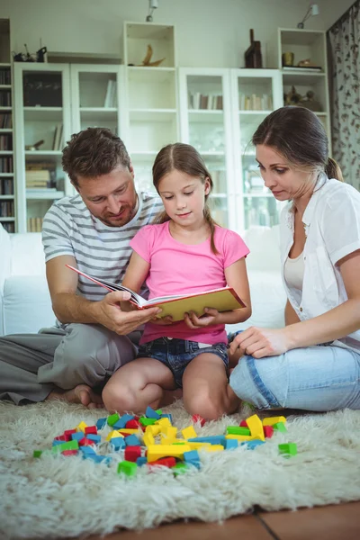 Genitori e figlia che leggono un libro — Foto Stock