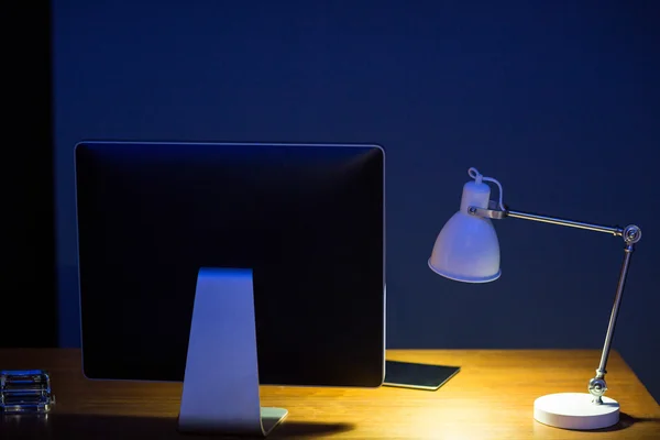 Computermonitor und beleuchtete Lampe — Stockfoto