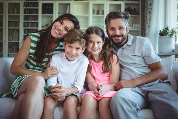 Happy family sitting on sofa — Stock Photo, Image