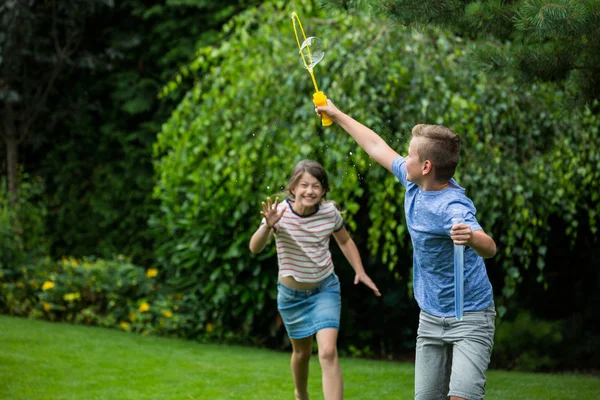 Kids playing with bubbles in the park — Stockfoto