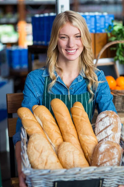 Mulher segurando uma cesta de baguetes — Fotografia de Stock