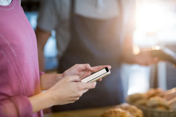 Kvinna som använder mobiltelefon på café — Stockfoto