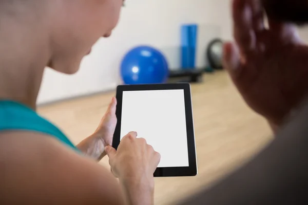 Frau zeigt Fitnesstrainerin Tablet — Stockfoto