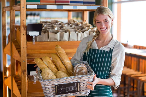 Anställda som innehar korg av bröd på bröd counter — Stockfoto