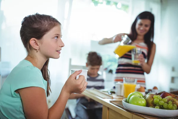 Mädchen trinkt Tasse Tee mit Familie — Stockfoto