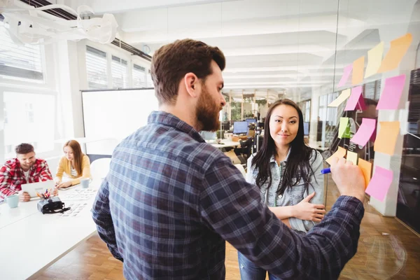 Business people writing on sticky notes — Stock Photo, Image