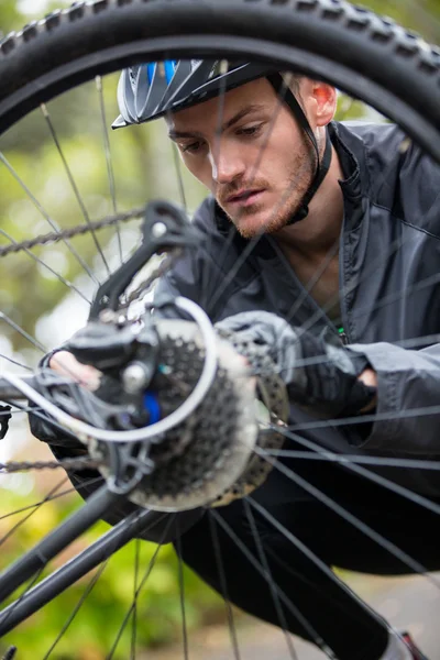 Чоловічий велосипедист ремонтує свій гірський велосипед — стокове фото