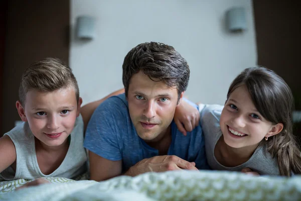 Father and kids lying in bedroom — Stockfoto