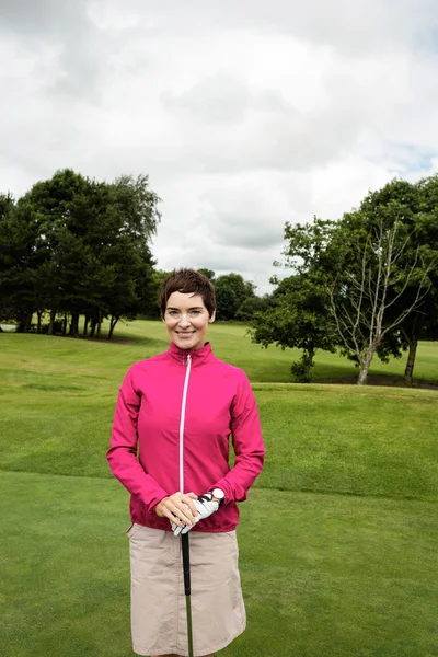 Kvinna som står med golfklubba — Stockfoto