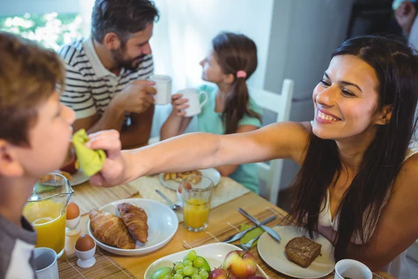 Happy woman feeding breakfast to his son — Stockfoto