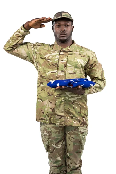 Żołnierz trzyma amerykańską flagę i pozdrawiając — Zdjęcie stockowe