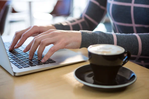 Donna che utilizza laptop con caffè sul tavolo — Foto Stock