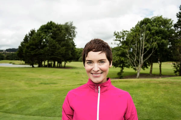 Woman standing in golf course — Stock Photo, Image