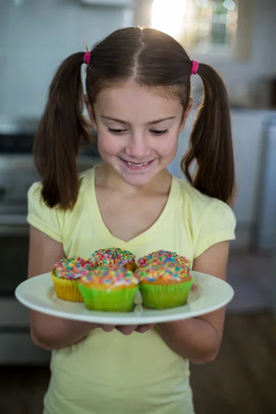 Mädchen mit einem Teller Cupcakes — Stockfoto