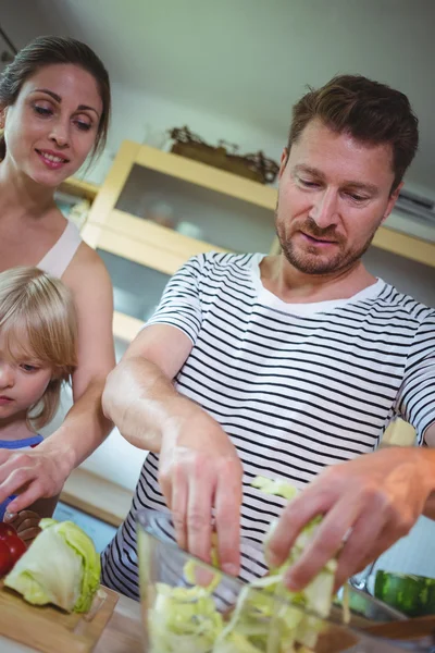 Famille préparant la salade dans la cuisine — Photo