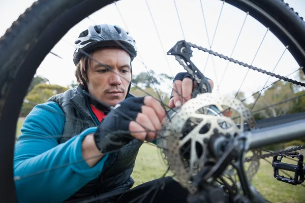 Ciclista de montaña macho fijando su cadena de bicicleta —  Fotos de Stock