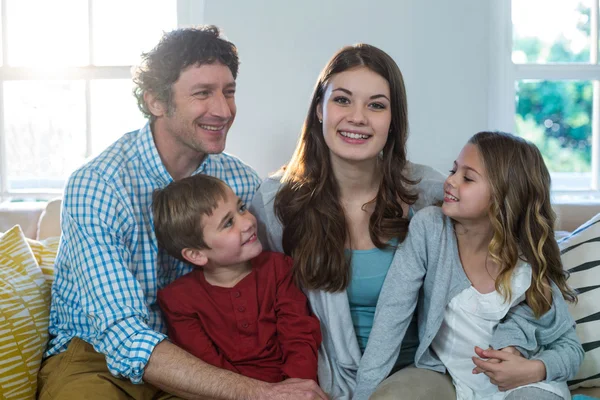 Família feliz sentado no sofá — Fotografia de Stock