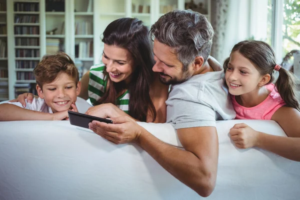 Parents sur canapé avec enfants utilisant le téléphone — Photo