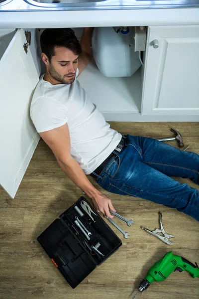 Hombre reparando un fregadero de cocina — Foto de Stock