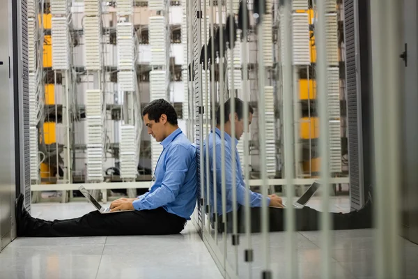 Technician working on laptop in hallway — Stock Photo, Image