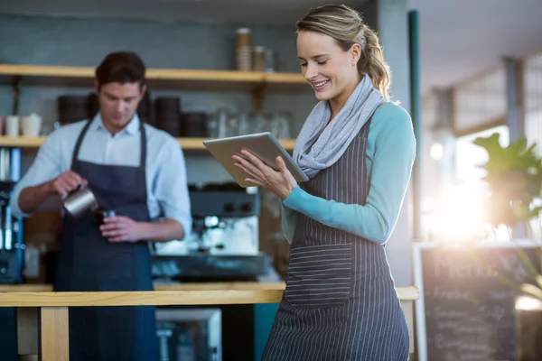 Waitress using tablet at counter