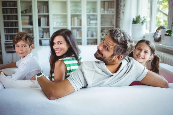 Happy family sitting on sofa — Stock Photo, Image