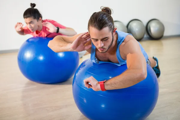 Hombres haciendo ejercicio sobre pelota de ejercicio — Foto de Stock