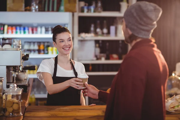 Waitress offering cup of coffee to customer — Stock Photo, Image