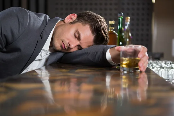 П'яний чоловік лежить на стійці — стокове фото