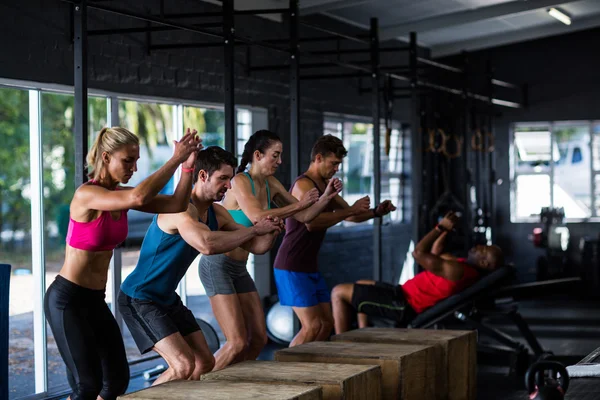 Människor lutar på trä kuber i gymmet — Stockfoto