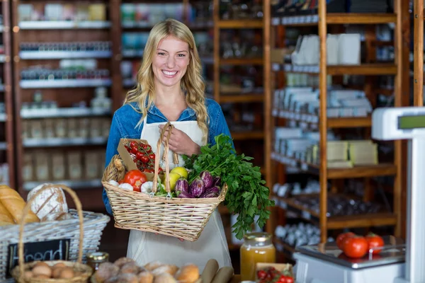 Anställda som innehar korg med grönsaker i organiska avsnitt — Stockfoto