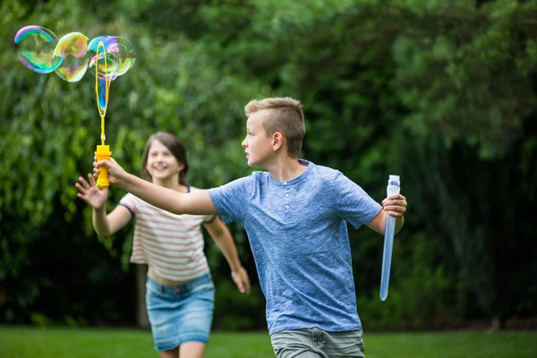 Niños jugando con burbujas en el parque — Foto de Stock