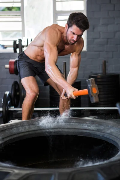 Male athlete exercising with sledgehammer — Stock Photo, Image