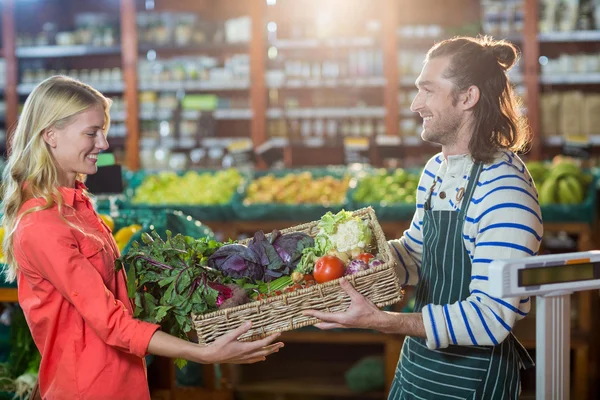 Personal masculino dando cajón de verduras frescas a la mujer — Foto de Stock