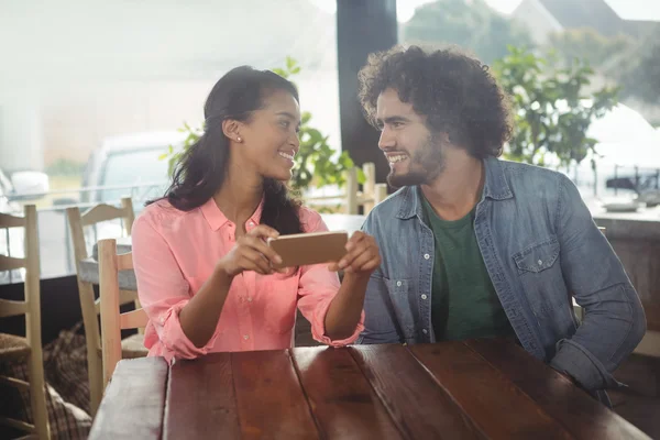 Paar schaut sich beim Halten von Handy an — Stockfoto