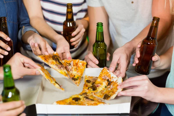 Barátai, amelyek üveg sört és pizza — Stock Fotó